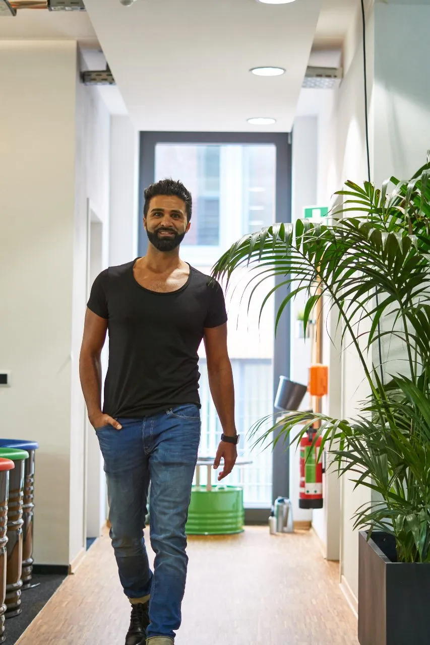 Sohrab Papahn in einem hellen Flur mit Pflanzen
