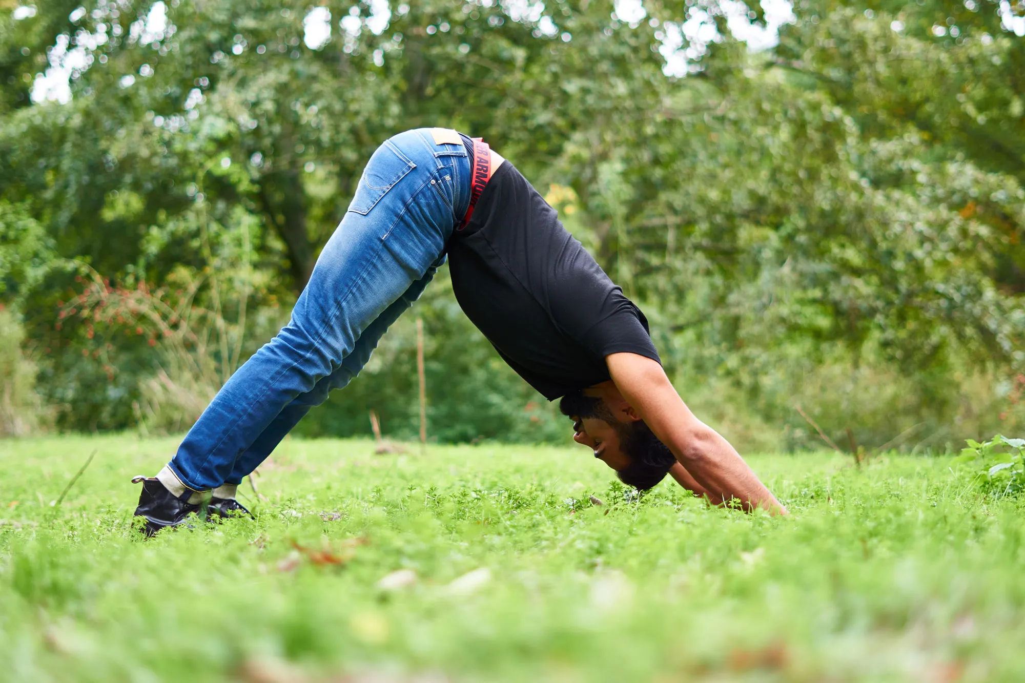Sohrab Papahn in einer Yogahaltung auf einer Wiese