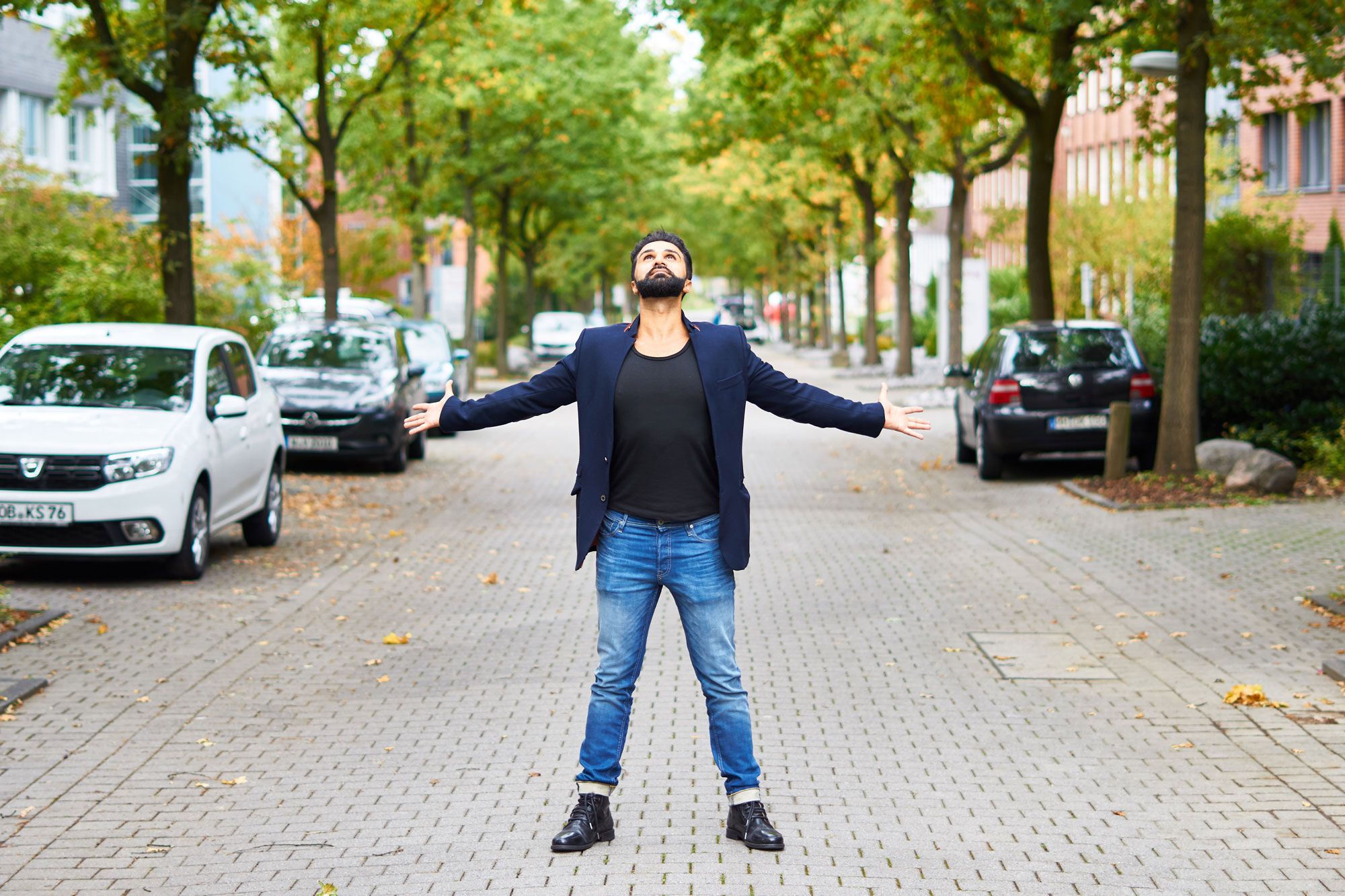 Sohrab Papahn steht mit ausgebreiteten Armen auf einer Straße